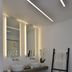 Margie Mykonos Hotel bathroom with double sinks, illuminated mirrors, towel ladder and wood bench