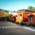 Hotel Del Pescador in Ajijic with red-orange guest buildings, palm trees, and mountain backdrop
