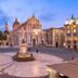 B&B Boutique di Charme Etna-Relax-Natura in Zafferana Etnea with a lit historic piazza and cathedral at dusk