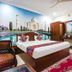 Hotel Taj Heritage room in Agra with Taj Mahal mural behind bed, wooden furniture, and red patterned rug
