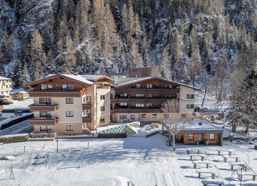Panorama Appartements in Längenfeld with snowy alpine setting and forest backdrop