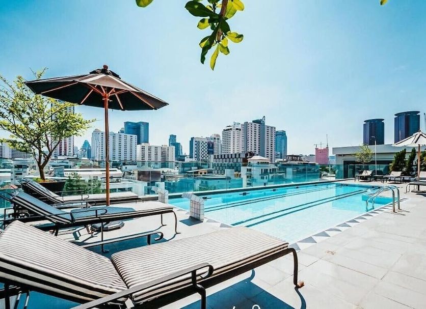 Vince Hotel Pratunam in Bangkok rooftop pool with loungers and city skyline view