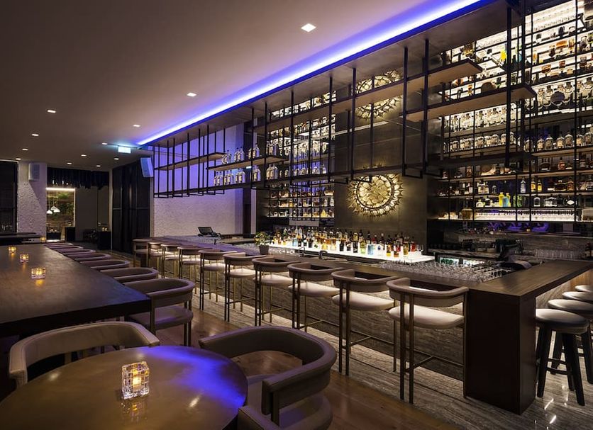 Intercontinental Hotels Doha Beach & Spa By IHG bar lounge in Doha with a long counter and backlit shelves