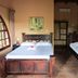 Hotel El Paraiso Escondido - Costa Rica room in Jacó with two wooden beds and tiled floor
