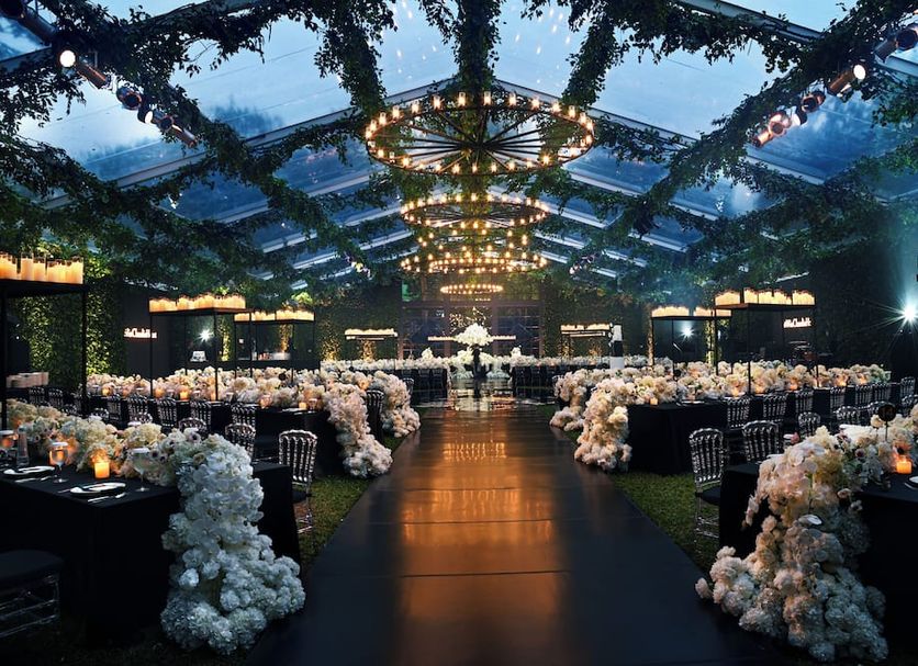 Hotel Borobudur Jakarta ballroom wedding setup with floral aisle and chandelier-lit glass ceiling