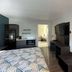Studio 6 Suites Lafayette room with two beds, TV, kitchenette, and full-length mirror in Lafayette