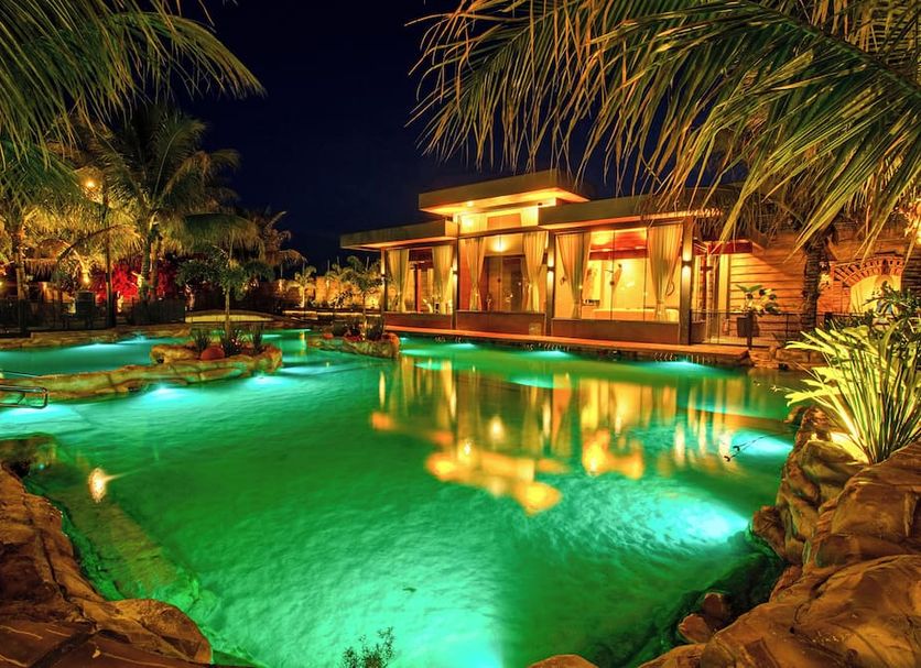 Carpe Diem Eco Resort Olímpia pool at night with glowing green water and tropical landscaping