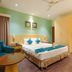 The Platinum Hotel Hyderabad guest room with double bed, teal accents, armchair and wardrobe