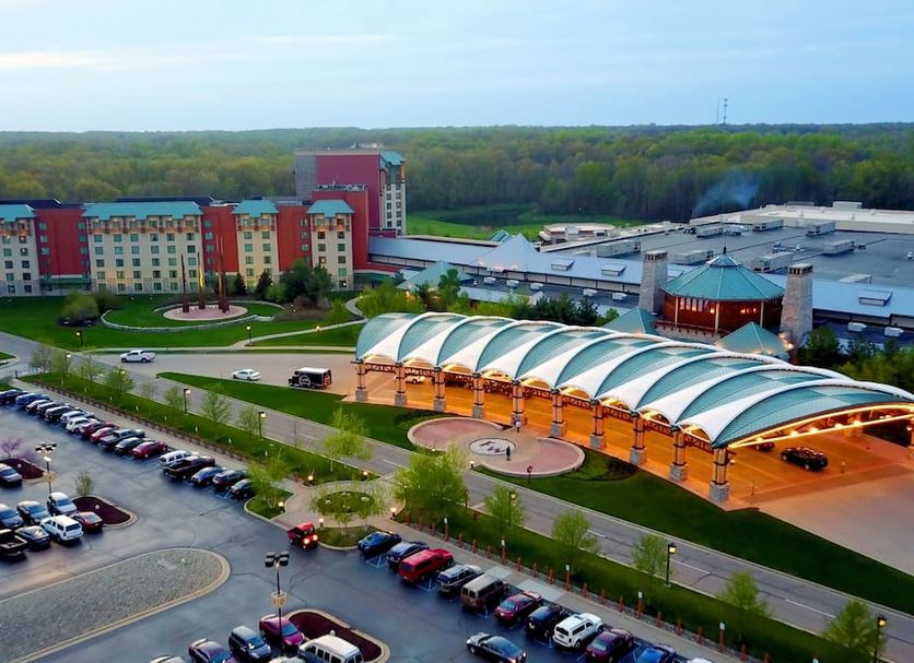 Four Winds Casino Resort in New Buffalo with a covered entrance, parking lot, and wooded horizon
