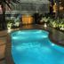 Hotel Antofagasta in Antofagasta with a lit outdoor pool surrounded by palm trees at night