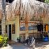 Mike's Dauin Dive Resort in Dauin with thatched entrance, welcome sign, and dive gear rack