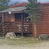 Denali RV Park and Motel in Healy: rustic wooden motel cabin with small porch and steps amid trees