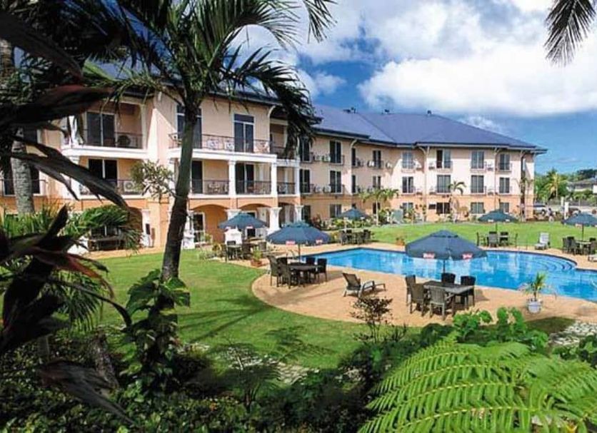 Tradewinds Hotel in Pago Pago with a palm-framed outdoor pool and three-story resort building