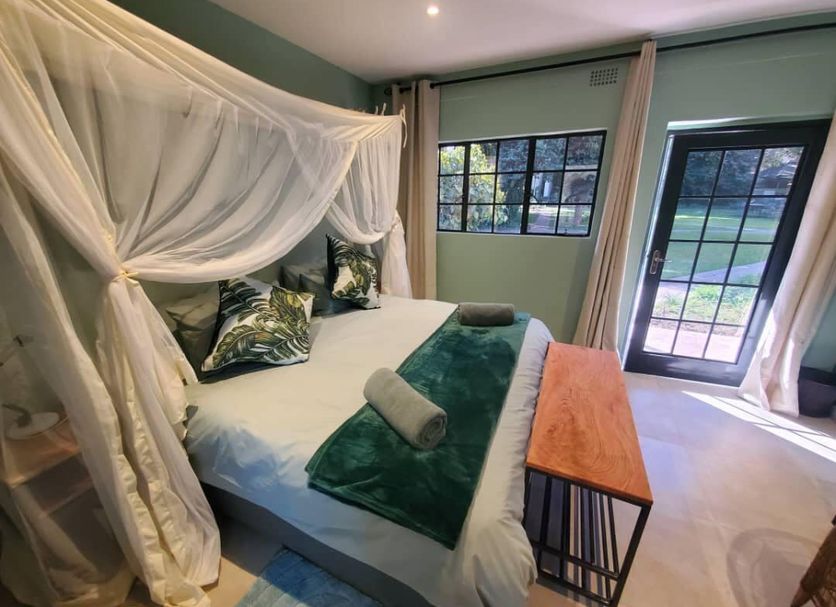 Fawlty Towers Accommodation & Activities room in Livingstone with canopy bed and garden view