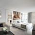 La Villa Haussmann Paris room with sofa, king bed, balcony doors and round mirror