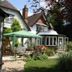 West Lodge Hotel in Aylesbury with a garden, patio seating, and a conservatory-style extension