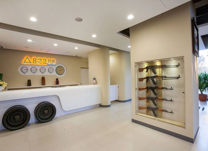 823 Tourist Hotel lobby in Jinhu Township with white front desk and wall-mounted rifle display
