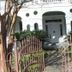 Dansereau House in Thibodaux, white historic hotel entrance with pink iron gate and landscaped front garden