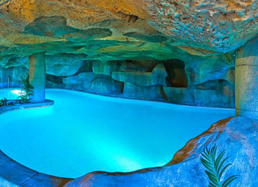 Playacartaya in Cartaya: illuminated indoor cave-style pool with rock ceiling and turquoise water