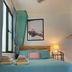 Coqui del Mar Guesthouse in San Juan, colorful guest room with teal bedspread and bedside lamp