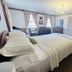 Bailey House in Annapolis Royal guest room with four-poster bed, chandelier, and antique armoire