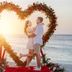 Amsterdam Manor Beach Resort, Noord: couple embracing in a heart-shaped flower arch on the beach at sunset