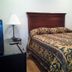 Arrowhead Mountain Inn in Lake Arrowhead: guest room with bed, bedside lamps, and wood headboard