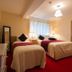 Aisleigh Guest House in Leitrim twin guest room with red carpet, two single beds, and window curtains
