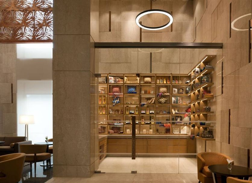 Feathers- A Radha Hotel, Chennai library lounge with bookshelves and seating