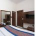 Vishal Hotel Near New Delhi Railway Station room with two beds, wall TV, air conditioner, and mirror