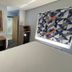 Jacksonville Inn & Suites guest room with desk, wall-mounted TV, and geometric accent wall in Jacksonville