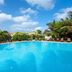 Melia Tortuga Beach in Santa Maria with a large outdoor pool and tropical palm trees under a blue sky