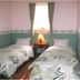 Pension Wave Inn in Itō: twin room with two single beds, bedside lamp, and curtained window