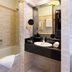 Melia Paris Champs Elysees bathroom in Paris with bathtub, vanity sink and marble walls