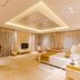 Xiang Ming Luxury Airport Hotel in Huangshan guest room with king bed, TV, seating area and sheer curtains