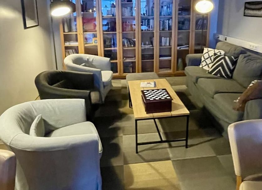 Hafnarstræti Hostel lounge in Akureyri with sofas, armchairs, coffee table and glass cabinet