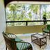 Hotel Cocomar Beachfront Hotel in Parrita balcony with green chairs and palm tree view