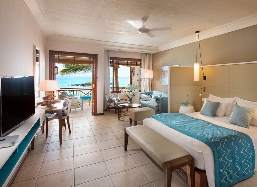 Constance Belle Mare Plage room with king bed, sitting area and balcony view toward the ocean in Belle Mare