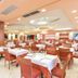 Hotel Club Astor in Ugento dining room with neatly set tables and orange chairs