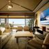 Four Seasons Resort Lanai suite with ocean-view balcony, seating area, and wall-mounted TV in Lanai City