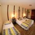 La Ferme de la Gronde, Bayeux: twin bedroom with patterned bedding and wooden wardrobe