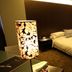 Zhuhai Zobon Art Hotel in Zhuhai guest room with bed, decorative floor lamp and glass-walled bathroom