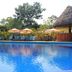 Hotel Villa Mercedes Palenque pool with loungers, umbrellas and lush tropical garden in Palenque