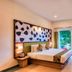 Sterling Wayanad in Sultan Bathery bedroom with king bed, leafy wall art and sliding glass doors to greenery