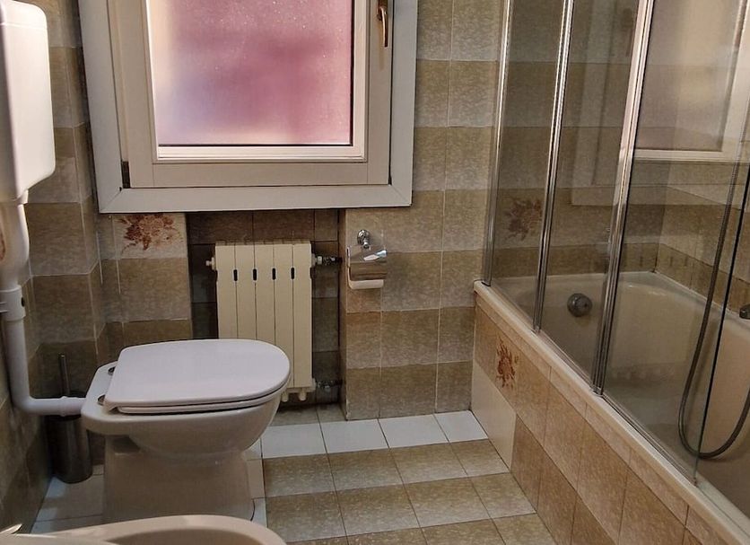 Hotel Tito Venice bathroom with toilet, sink, and glass shower/tub combo