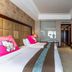 Xinhua Jianguo Hotel in Jiujiang guest room with twin beds, wall-mounted TV and wood-paneled furnishings