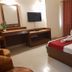 Hotel Maiden Residency room in Ghāziābād with double bed, TV, desk and red curtains