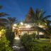 Hotel Vai Moana in Hanga Roa at dusk, with palm trees, garden path and lit tropical lodge exterior