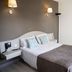 Le Neoulous in Le Boulou guest room with double bed, bedside lamps and small desk