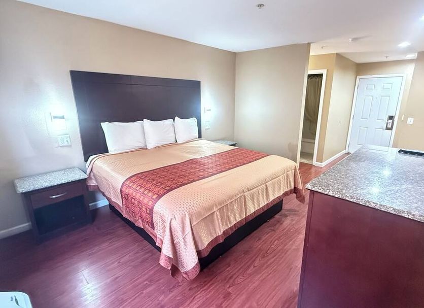 Valley Inn Watsonville guest room with king bed, wood floors, and kitchenette counter